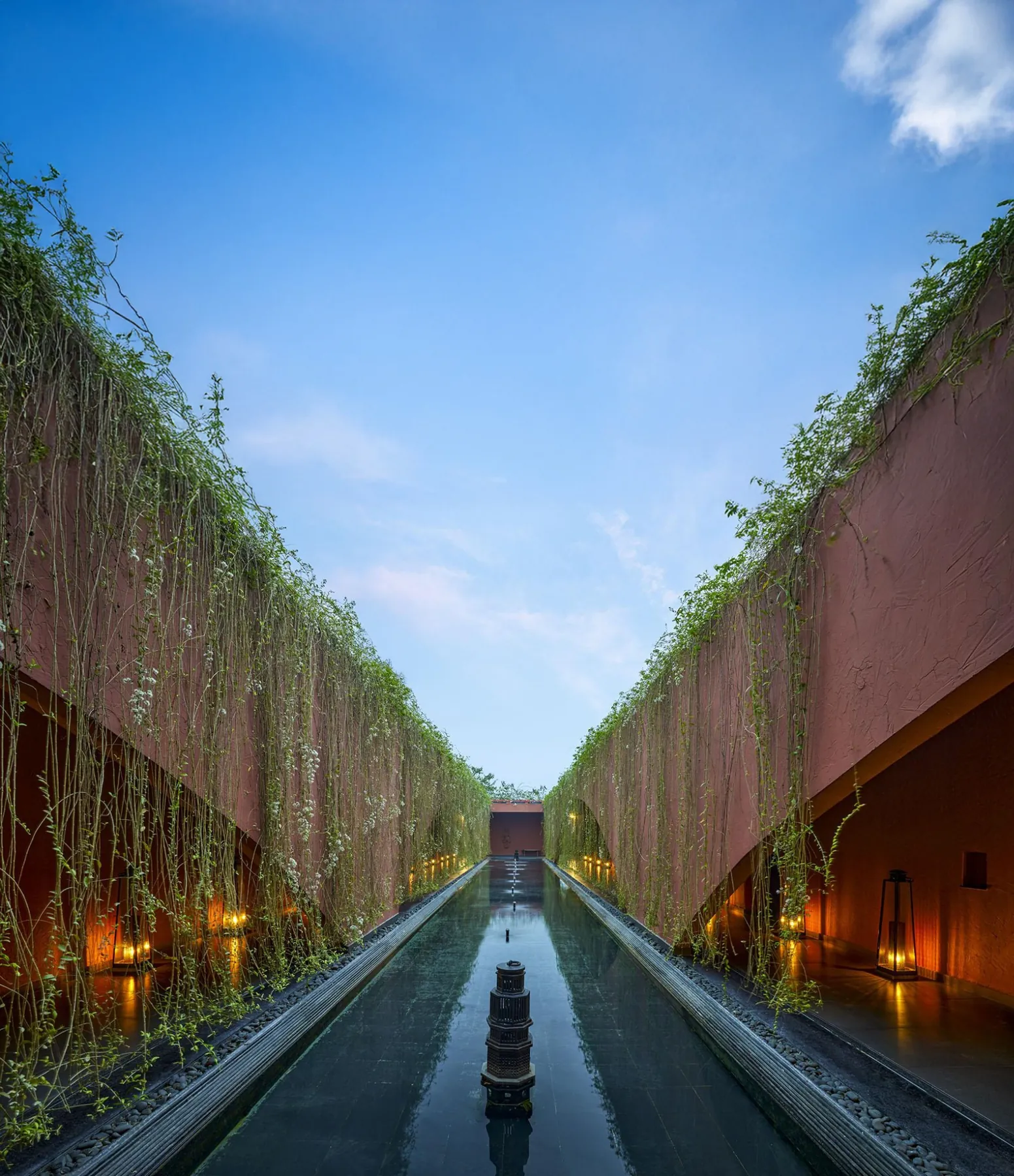 Long reflecting channel beneath trailing plants between Devasom’s terracotta walls