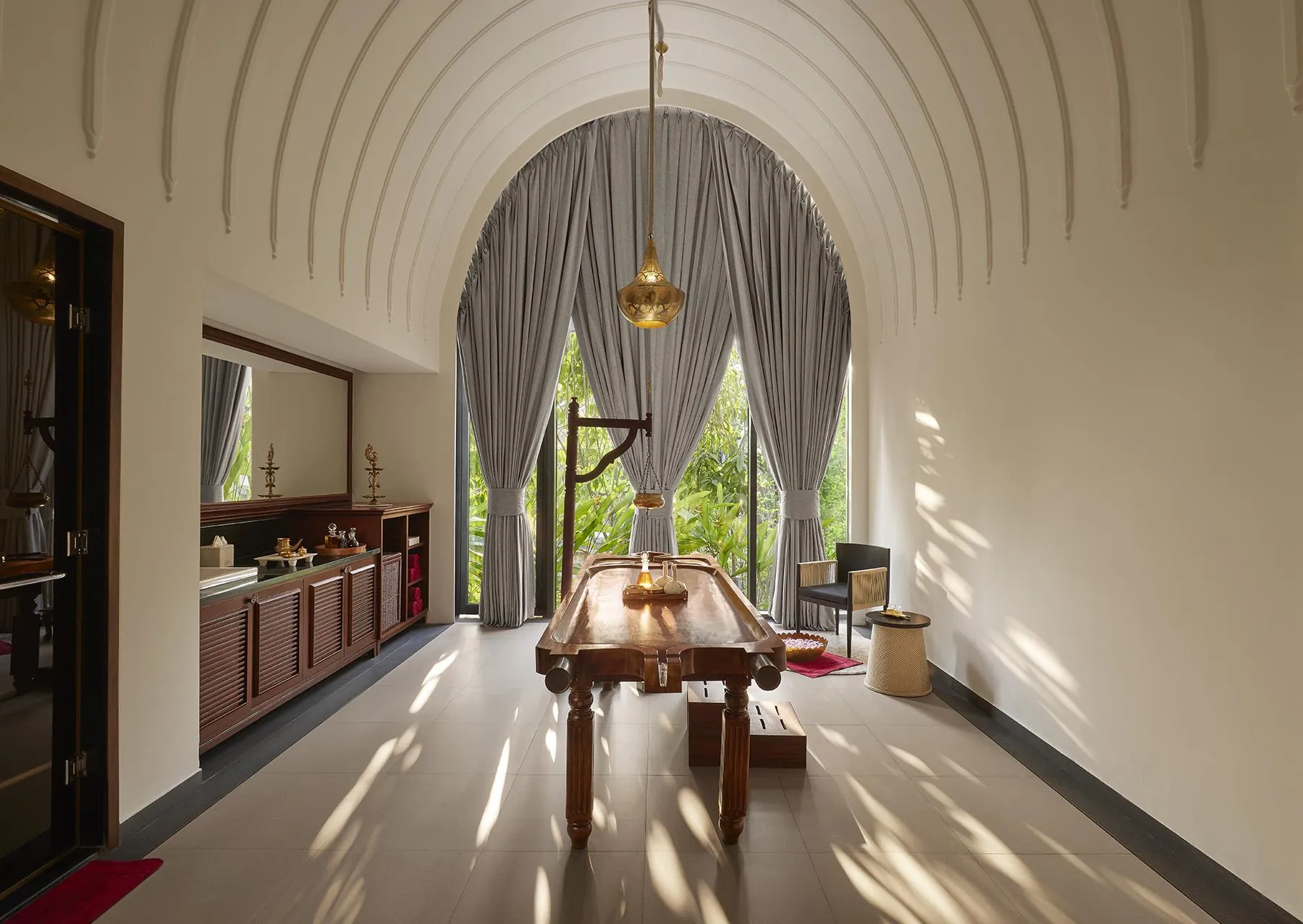 Dining room beneath a ribbed vaulted ceiling with views towards planting at Devasom