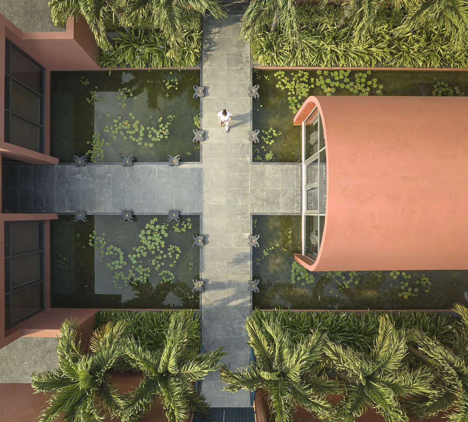 Overhead view of the water courtyard, stone paths and palm planting at Devasom