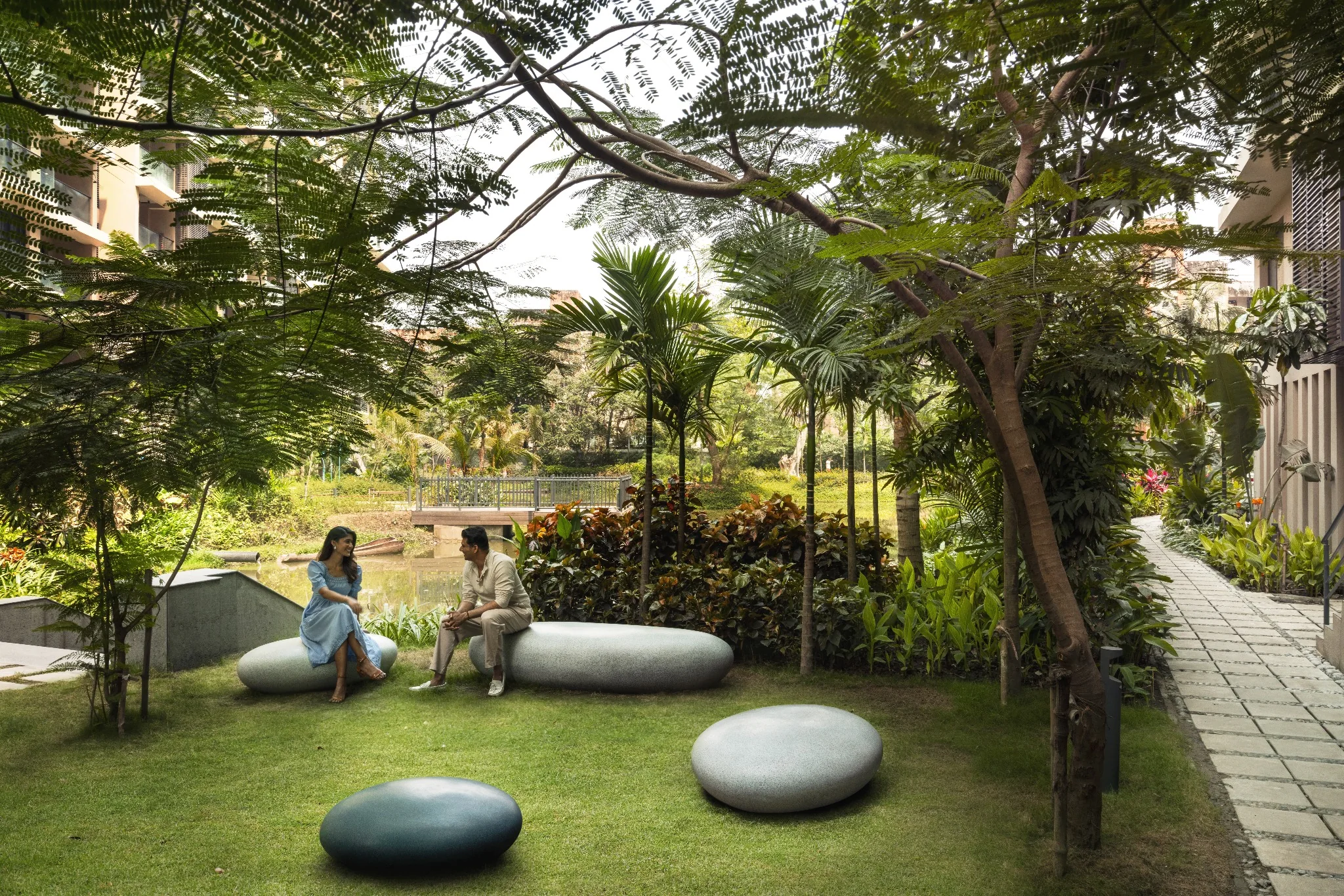 Residents in a shaded garden gathering space beside the lake at Jiva Homes