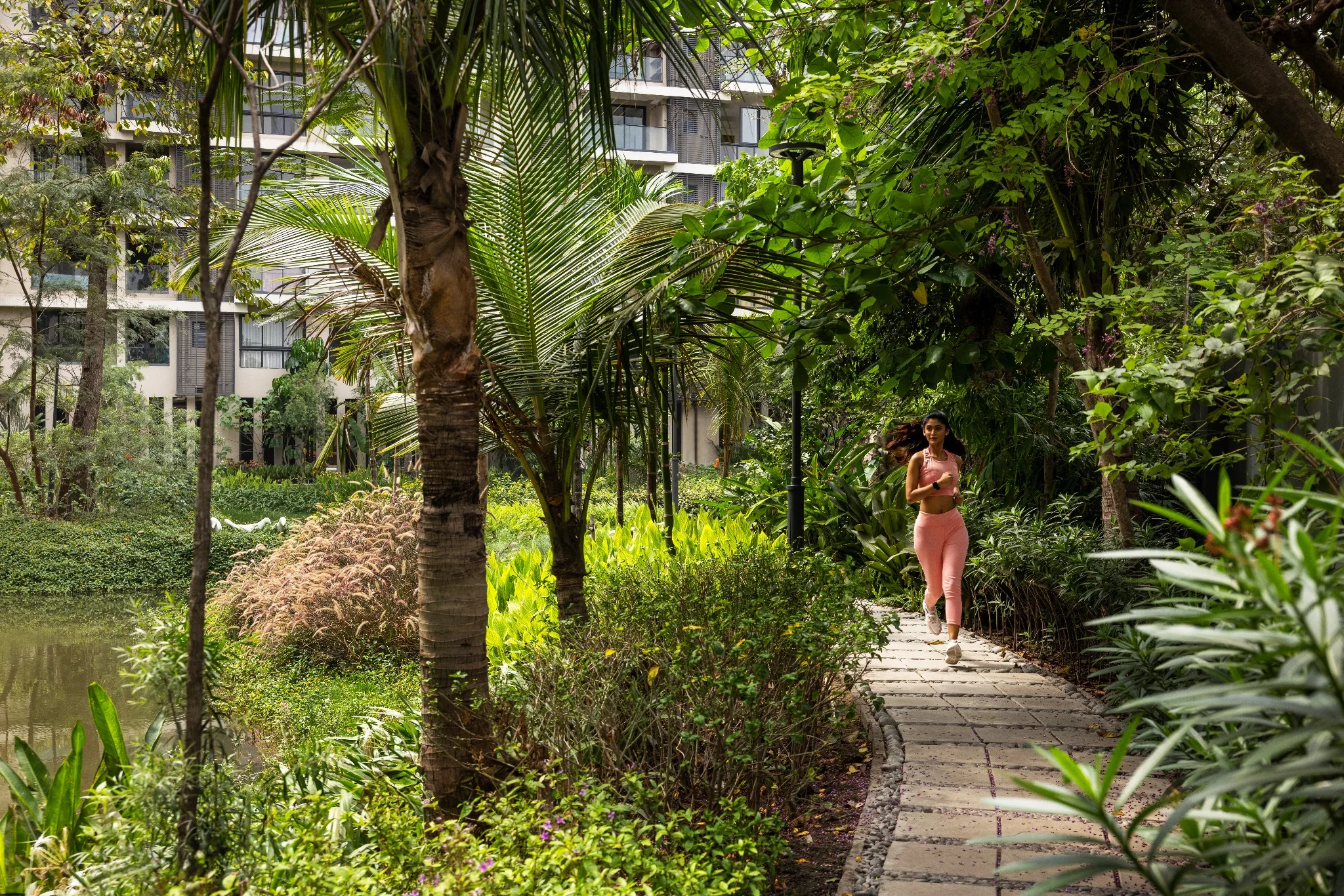A resident walking along a shaded garden path at Jiva Homes