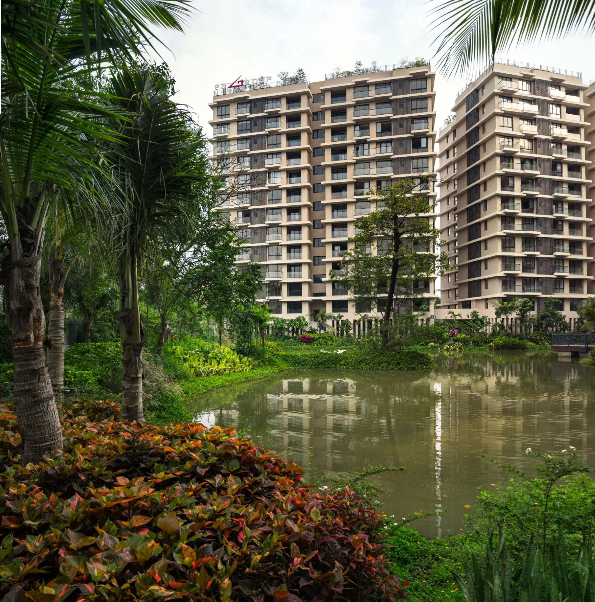 Lake and residential facades framed by palms at Jiva Homes