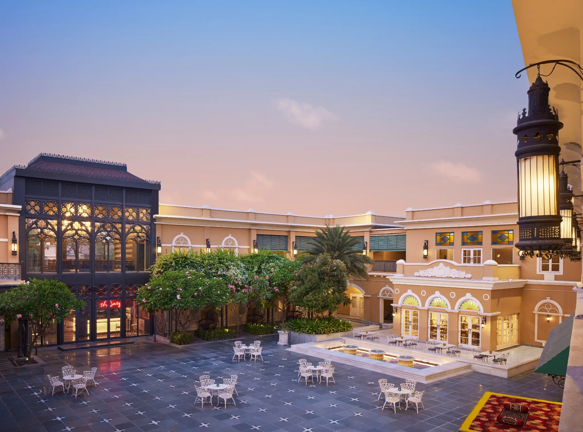 Shared Raajkutir courtyard at dusk with Swig’s black cast-iron facade on the left, Swabhumi – The Heritage, Kolkata
