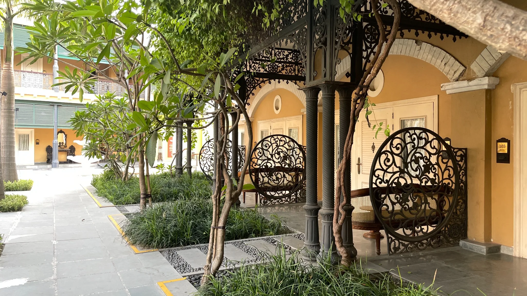 Ornamental swing seats along a shaded garden verandah at IHCL SeleQtions – Raajkutir, Kolkata