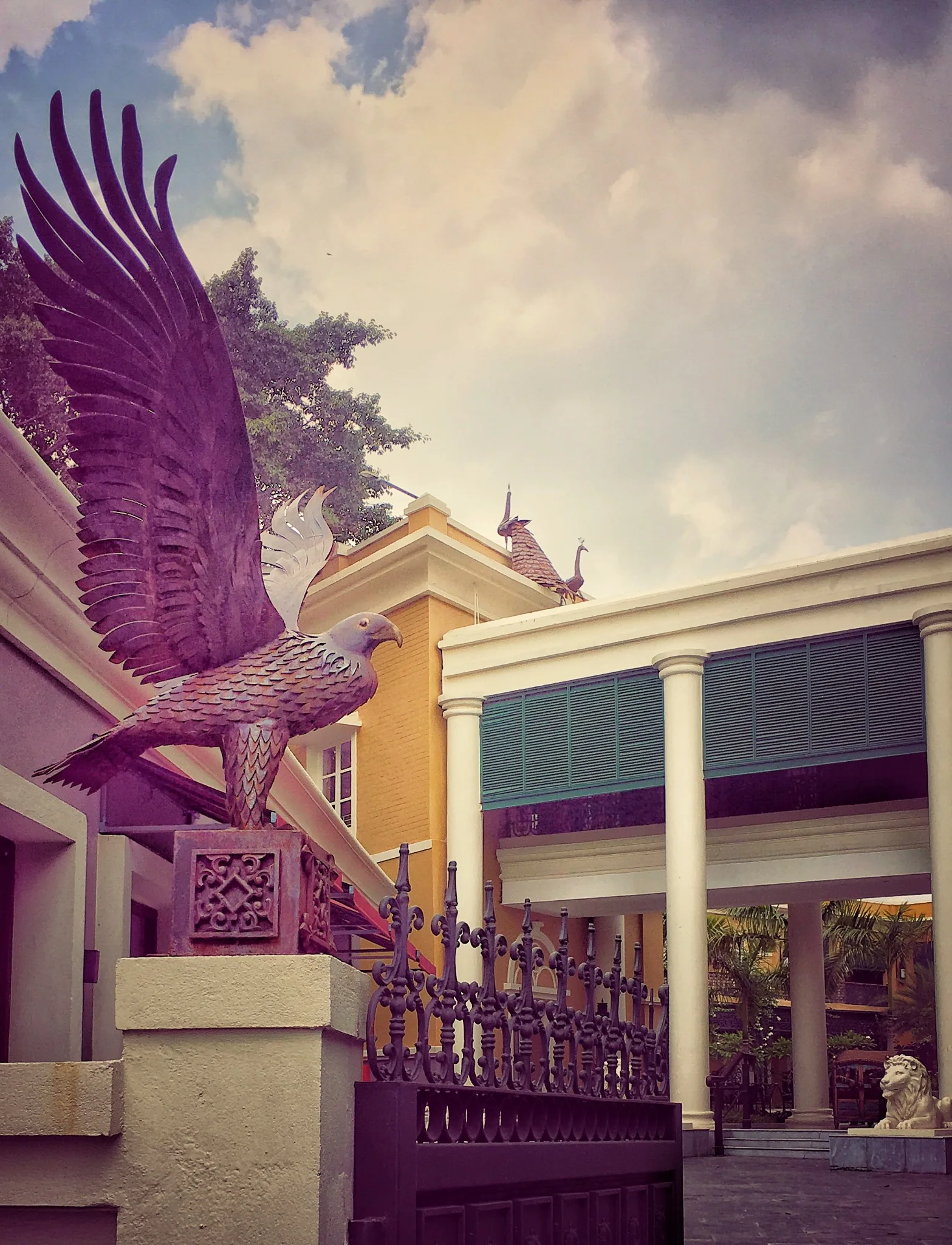 Bird sculpture and courtyard facades beneath an open sky at IHCL SeleQtions – Raajkutir, Kolkata