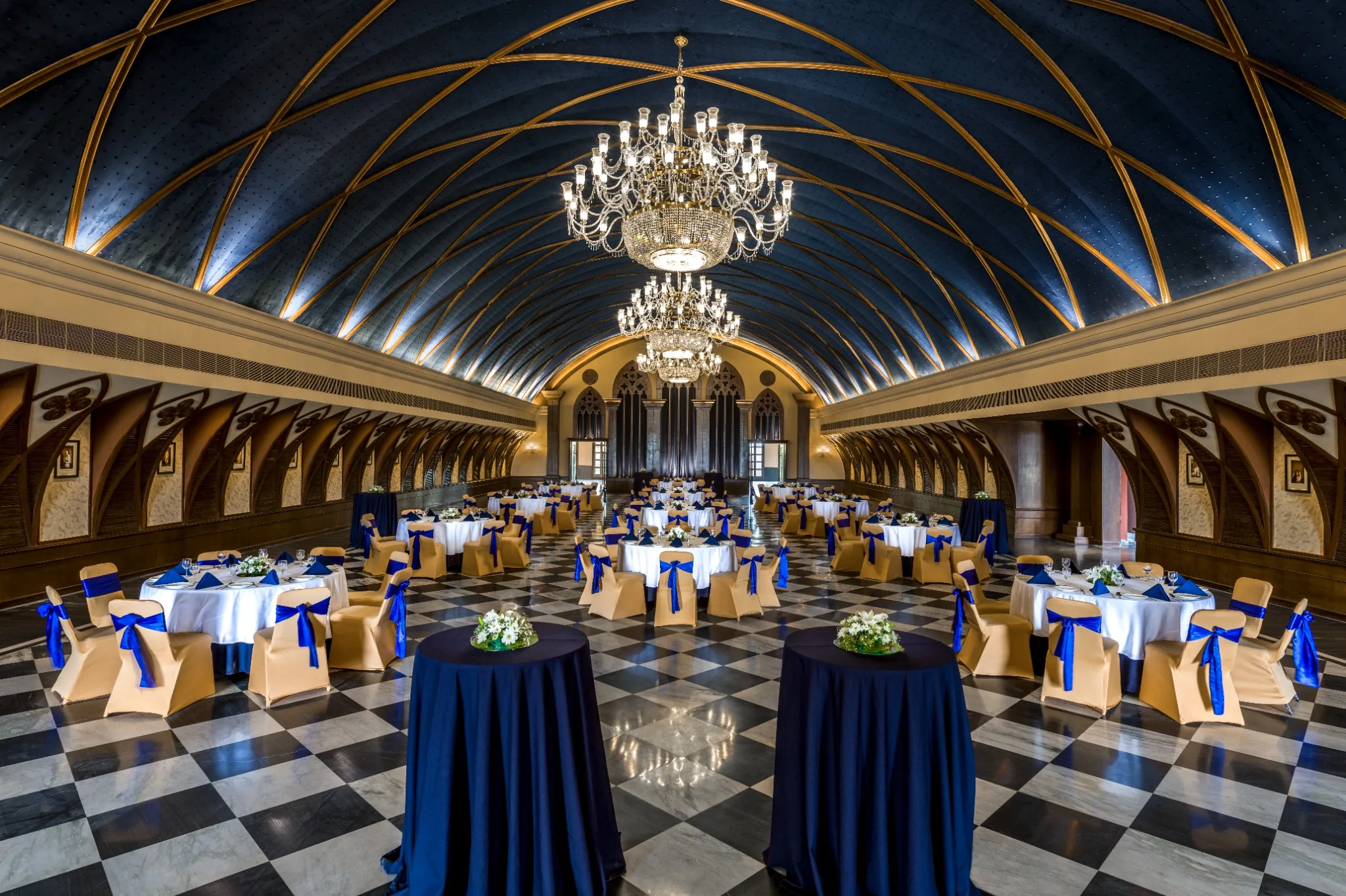 Banquet hall with a blue vaulted ceiling, chandeliers and a chequered floor at IHCL SeleQtions – Raajkutir, Kolkata