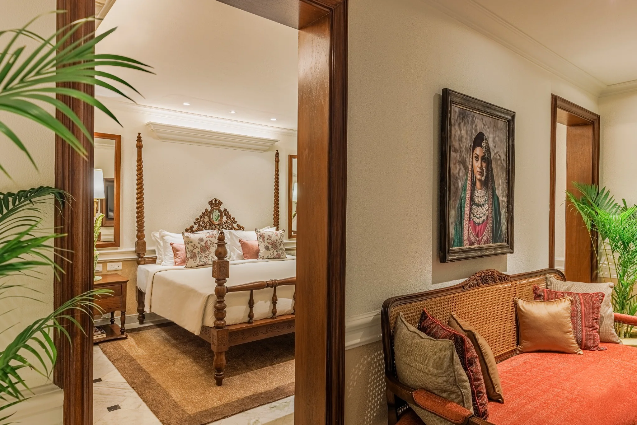 Guest suite with carved timber furniture, portrait artwork and a four-poster bed at Serai Block, Kolkata